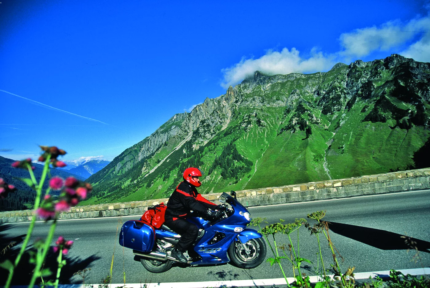 Motorrad auf der Arlbergstraße vor grün bewachsener Bergflanke Motorrad auf der Arlbergstraße vor grün bewachsener Bergflanke